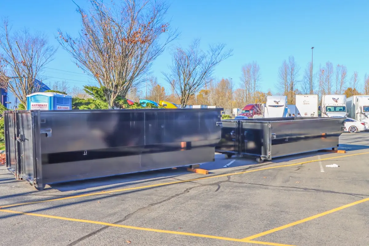 Professional dumpster rental service with roll-off container on residential driveway in Bel Air